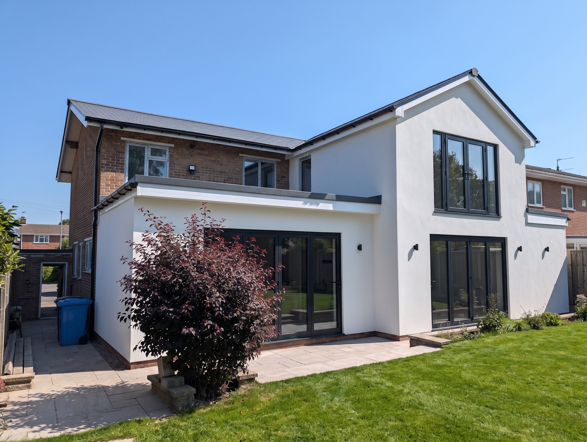 Two-storey and single-storey rear extension with white render and anthracite bifold doors, Sheffield